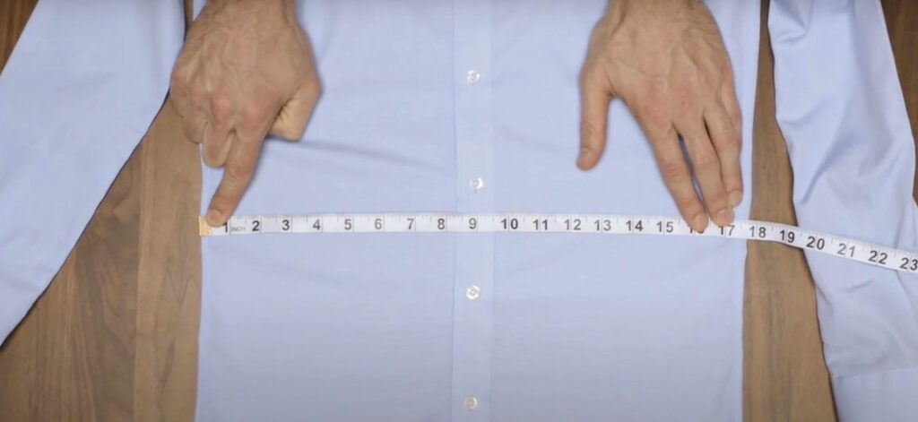 Measuring tape on a flat shirt showing midsection width